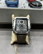 Luxury watch with transparent case back on a gray surface