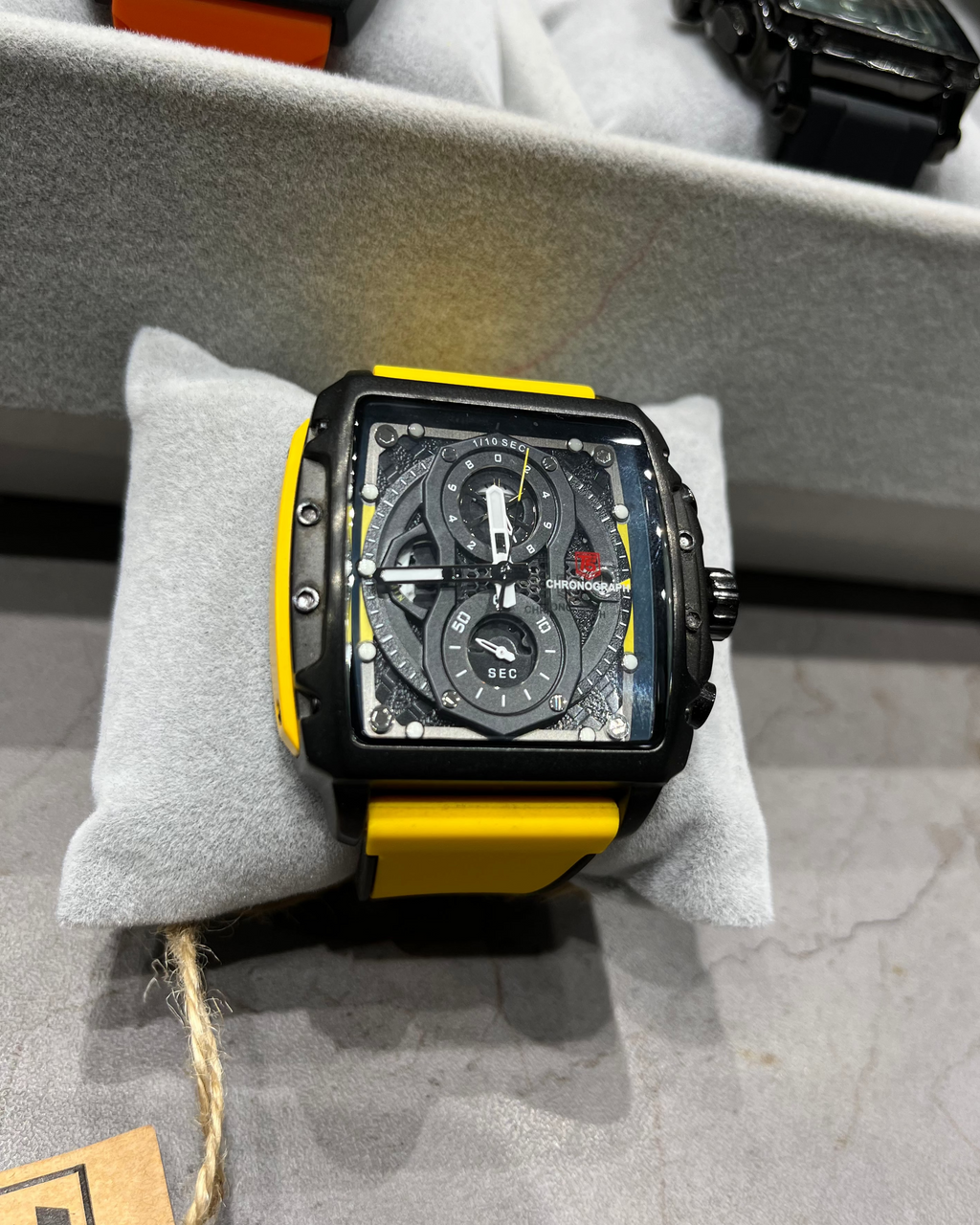 Watch with a yellow strap on a gray surface