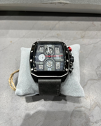 Black wristwatch with detailed face on a gray cushion, on a textured surface