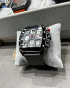 Black wristwatch on a gray cushion with blurred background