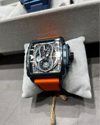 Watch with orange strap on a gray surface