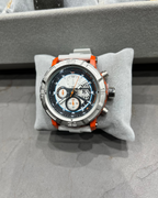 Chronograph watch with orange accents on a gray cushion