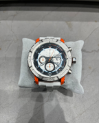 Luxury watch with a detailed face on a gray cushion against a marble background