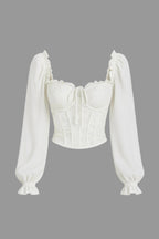 White blouse with long sleeves on a light gray background